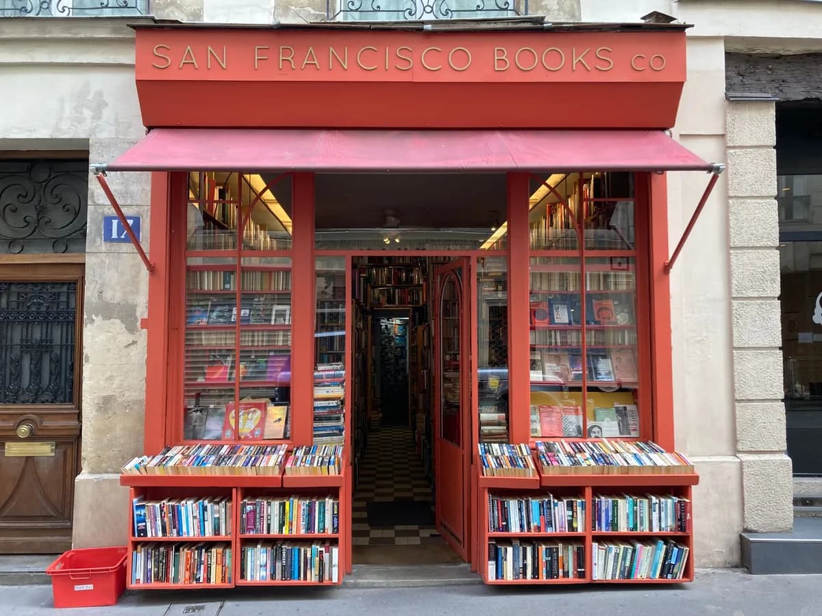 Devanture chaleureuse d'une librairie parisienne indépendante avec des livres en vitrine
