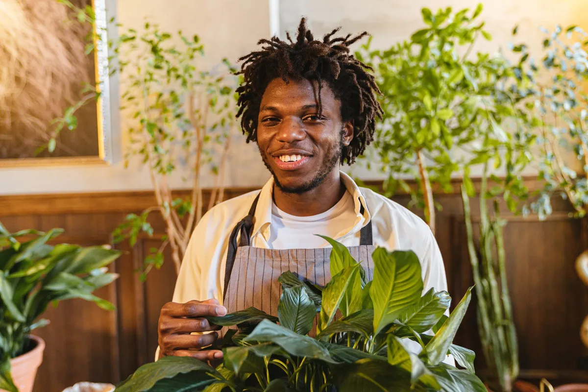 Céramiste afro travaillant l'argile dans son atelier parisien, bols et vases aux motifs graphiques inspirés d'Afrique posés sur l'établi
