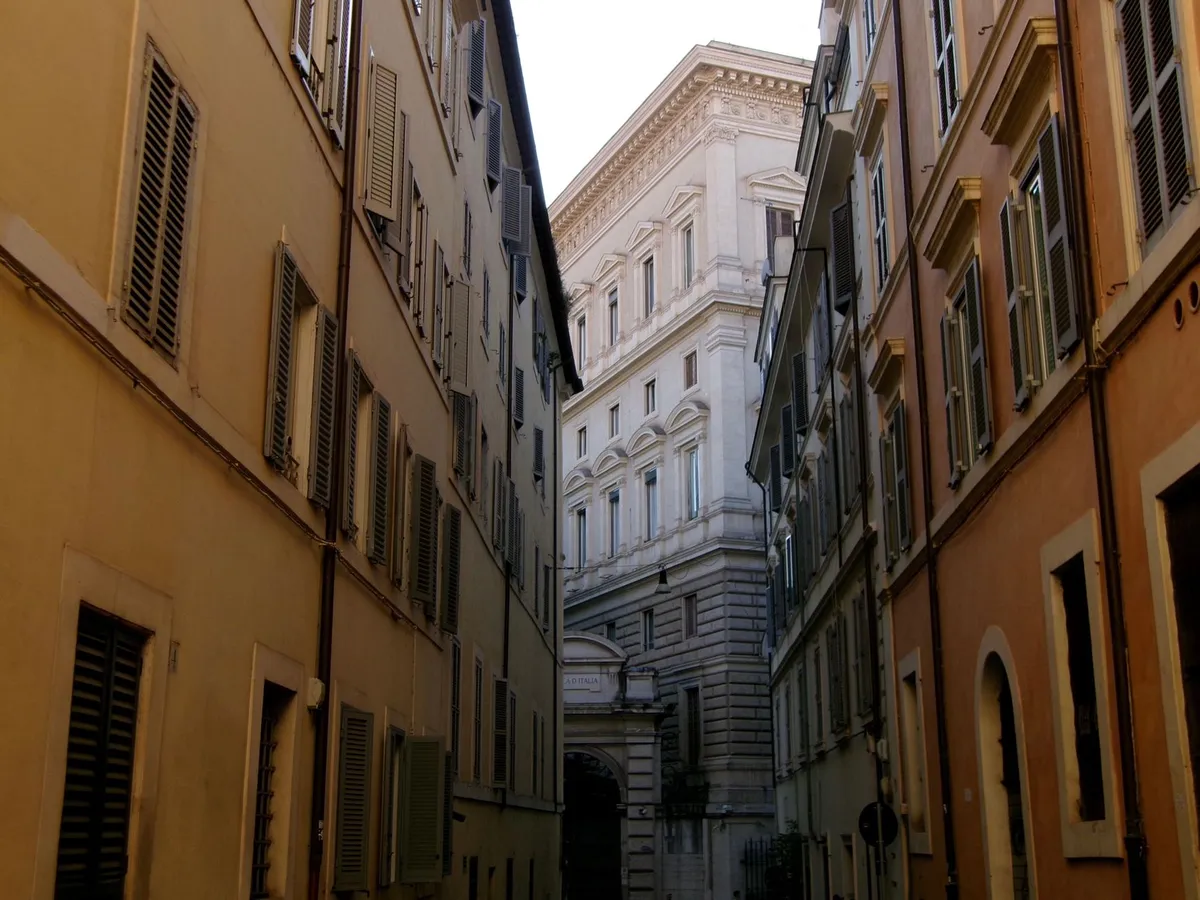 Rue animée de Rome au coucher du soleil avec façades colorées et passants, ambiance de quartier multiculturel