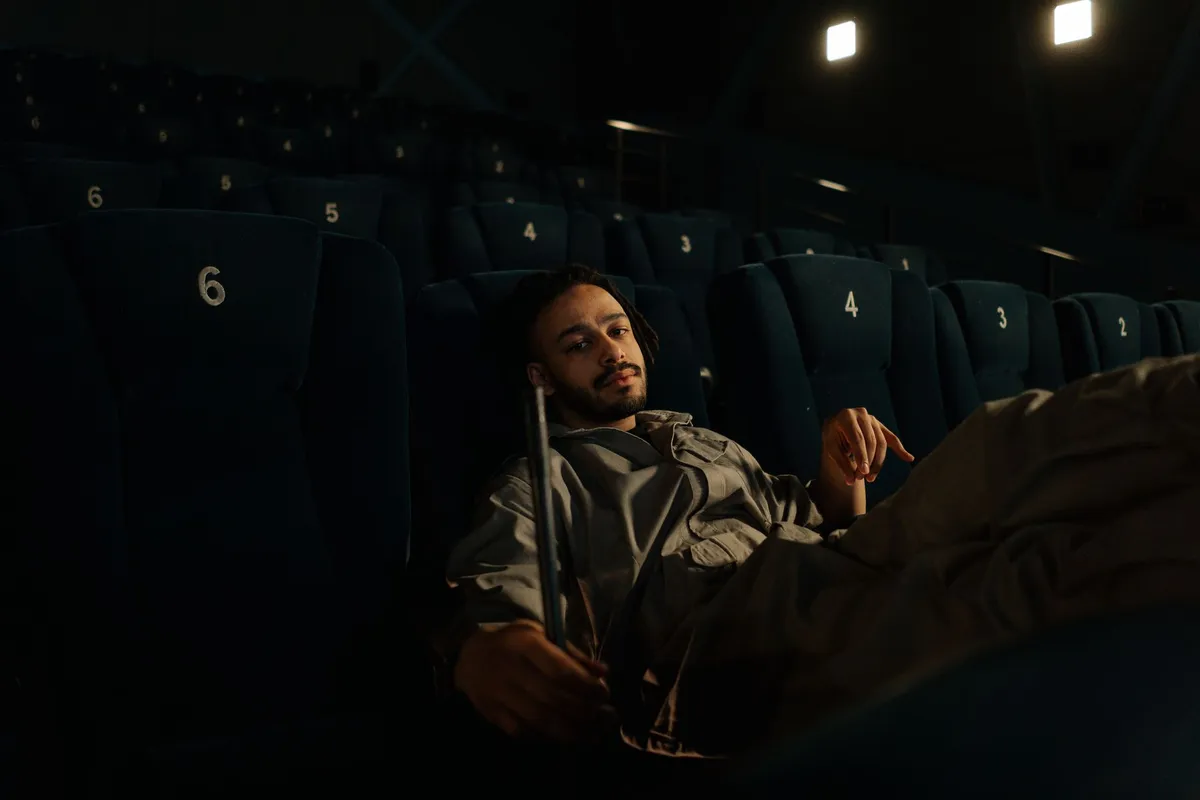 Réalisatrice afro-descendante derrière une caméra dans une salle de cinéma parisienne, lumière dorée et chaude