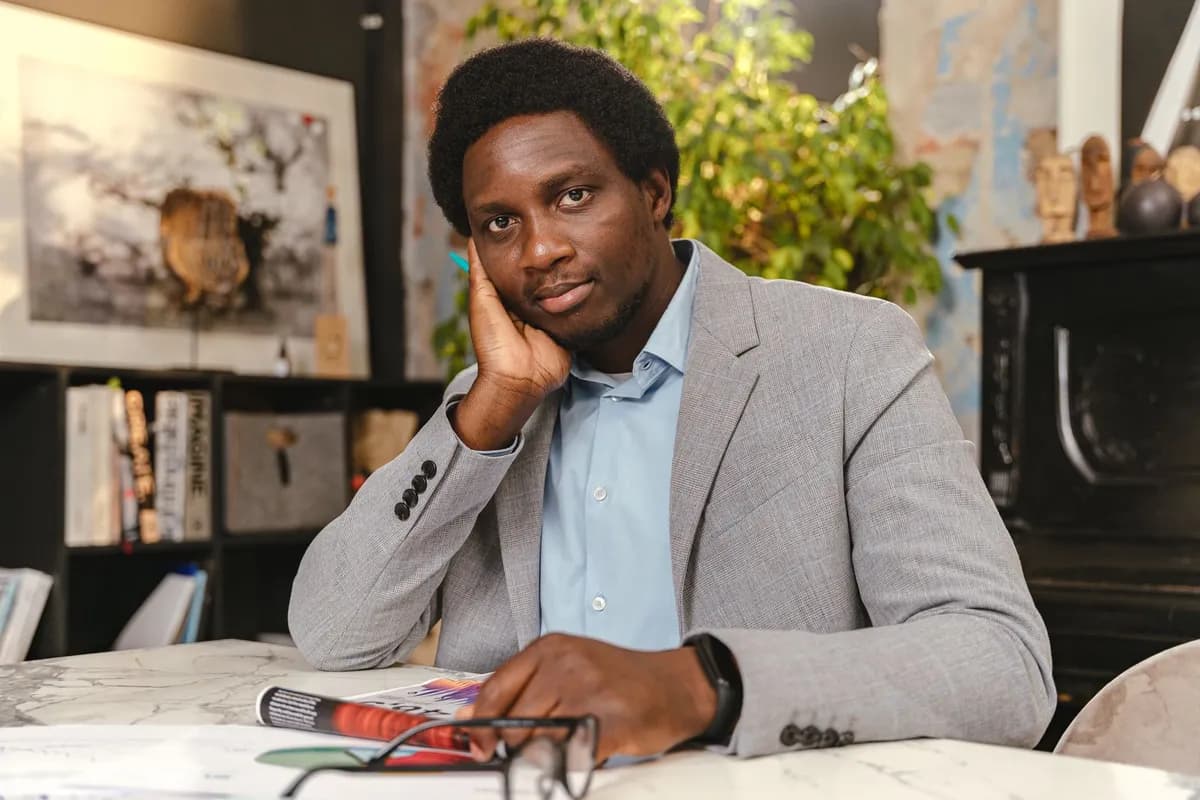Femme entrepreneur afro souriante dans un espace de coworking parisien, ordinateur ouvert, ambiance lumineuse et moderne