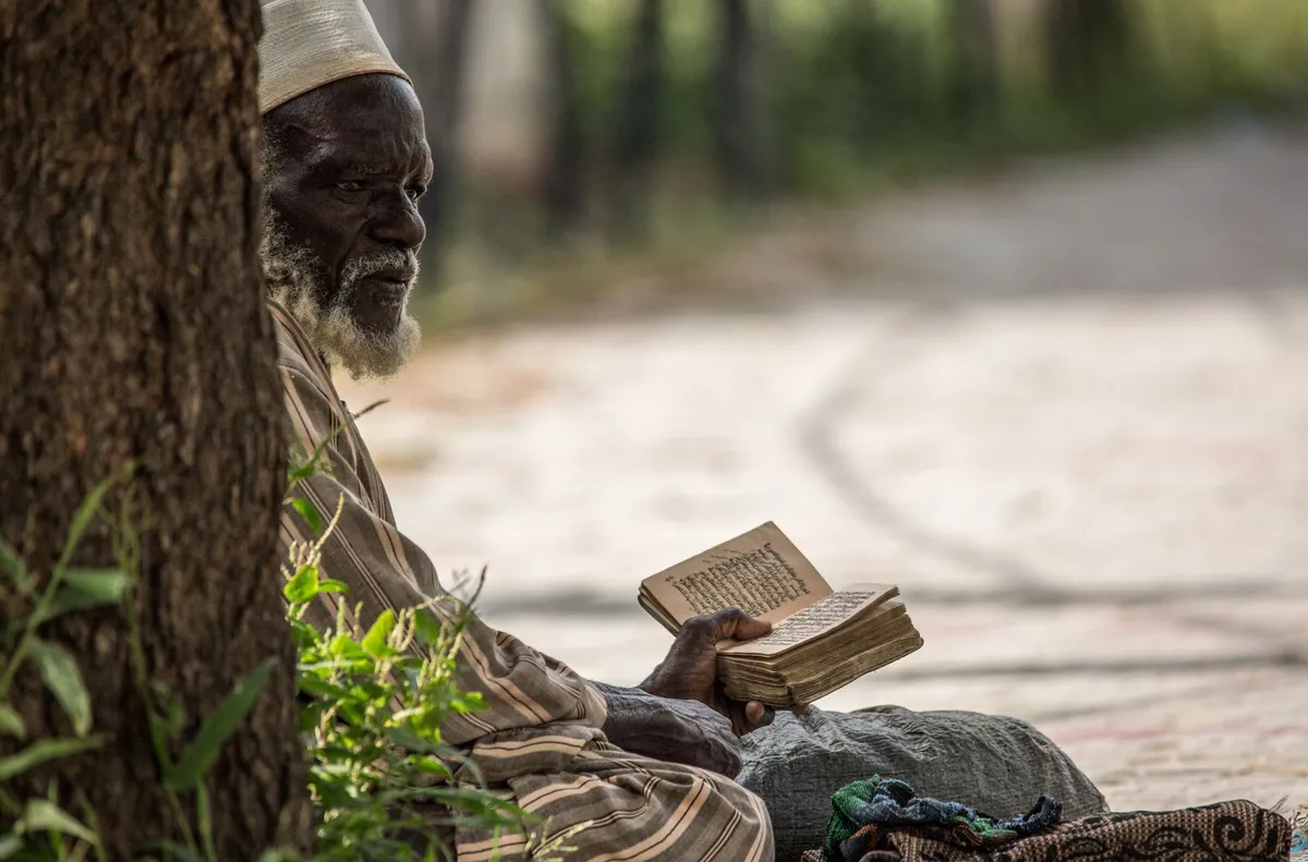 Pile de livres d'auteurs africains et afropéens posée sur une table en bois dans une librairie parisienne lumineuse