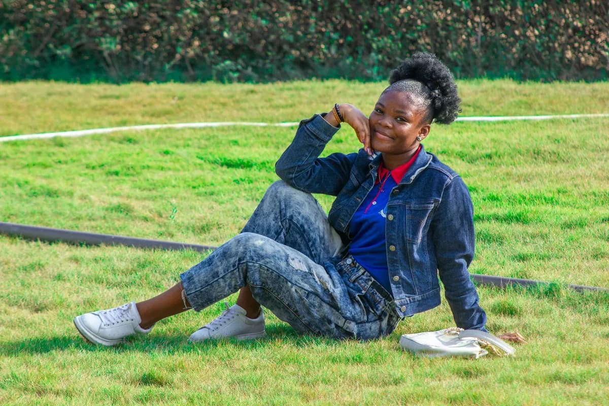 Femme élégante portant une tenue en wax coloré dans une rue parisienne ensoleillée, sac à main structuré et sneakers blanches