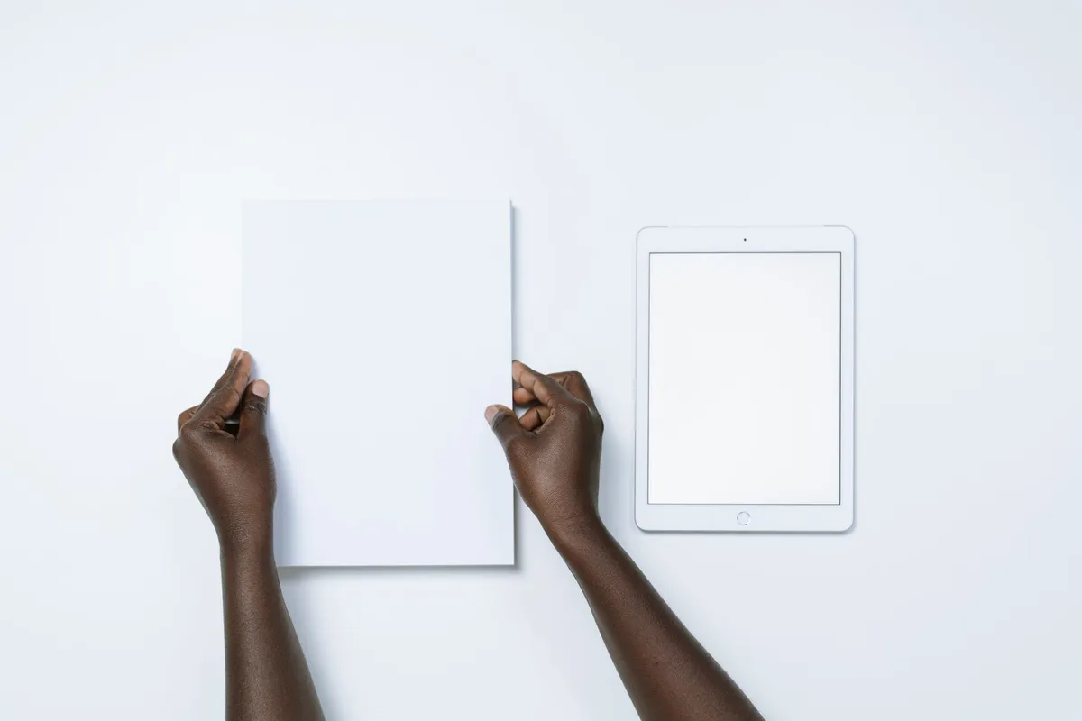 Bureau lumineux à Paris décoré d'un carnet à couverture wax, d'une affiche graphique et d'un stylo doré posé sur un sous-main en cuir