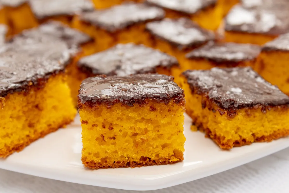 Assortiment de pâtisseries camerounaises : beignets dorés, gâteau de maïs et croquants aux arachides sur une table en bois