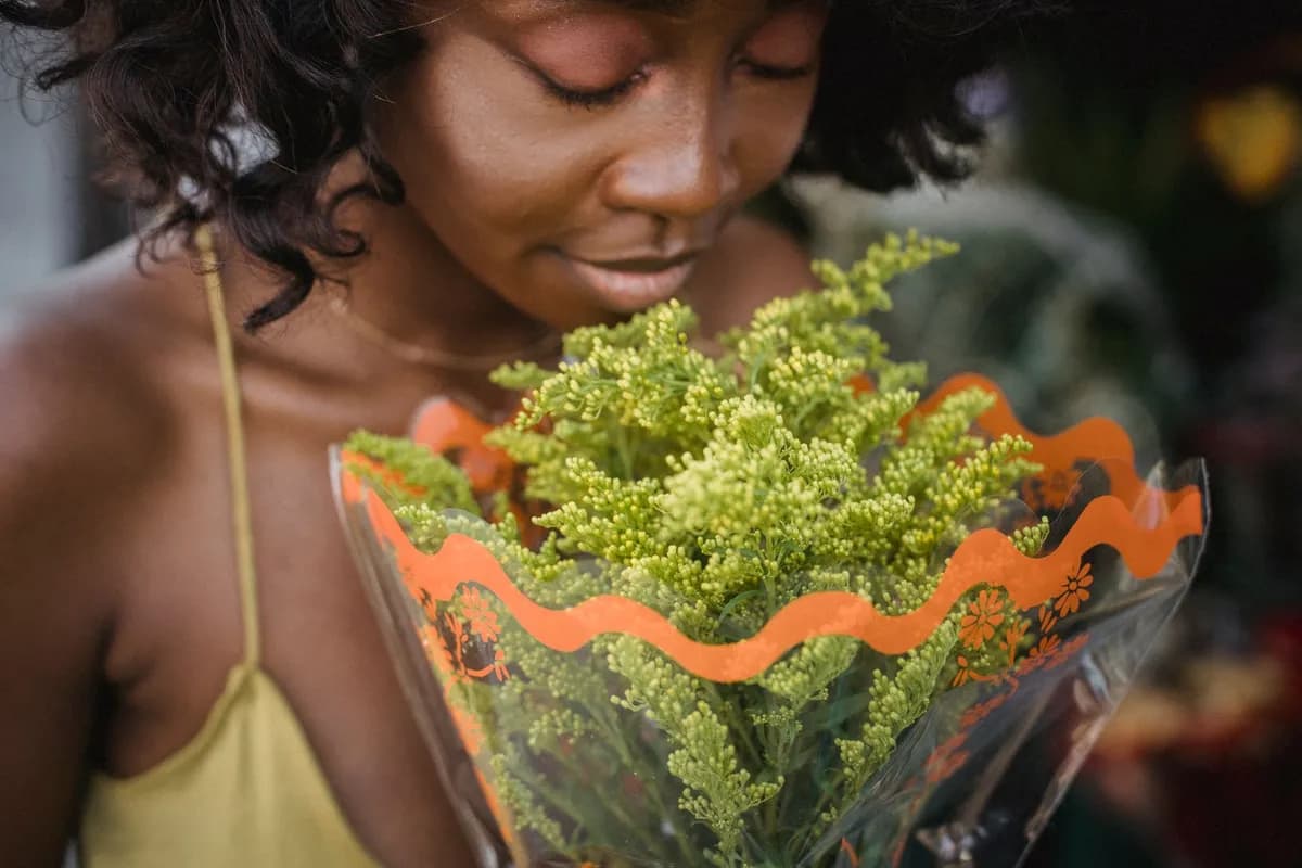 Awa, fleuriste afro à Paris, compose un bouquet dans son atelier lumineux aux côtés de fleurs tropicales et de fleurs de saison.