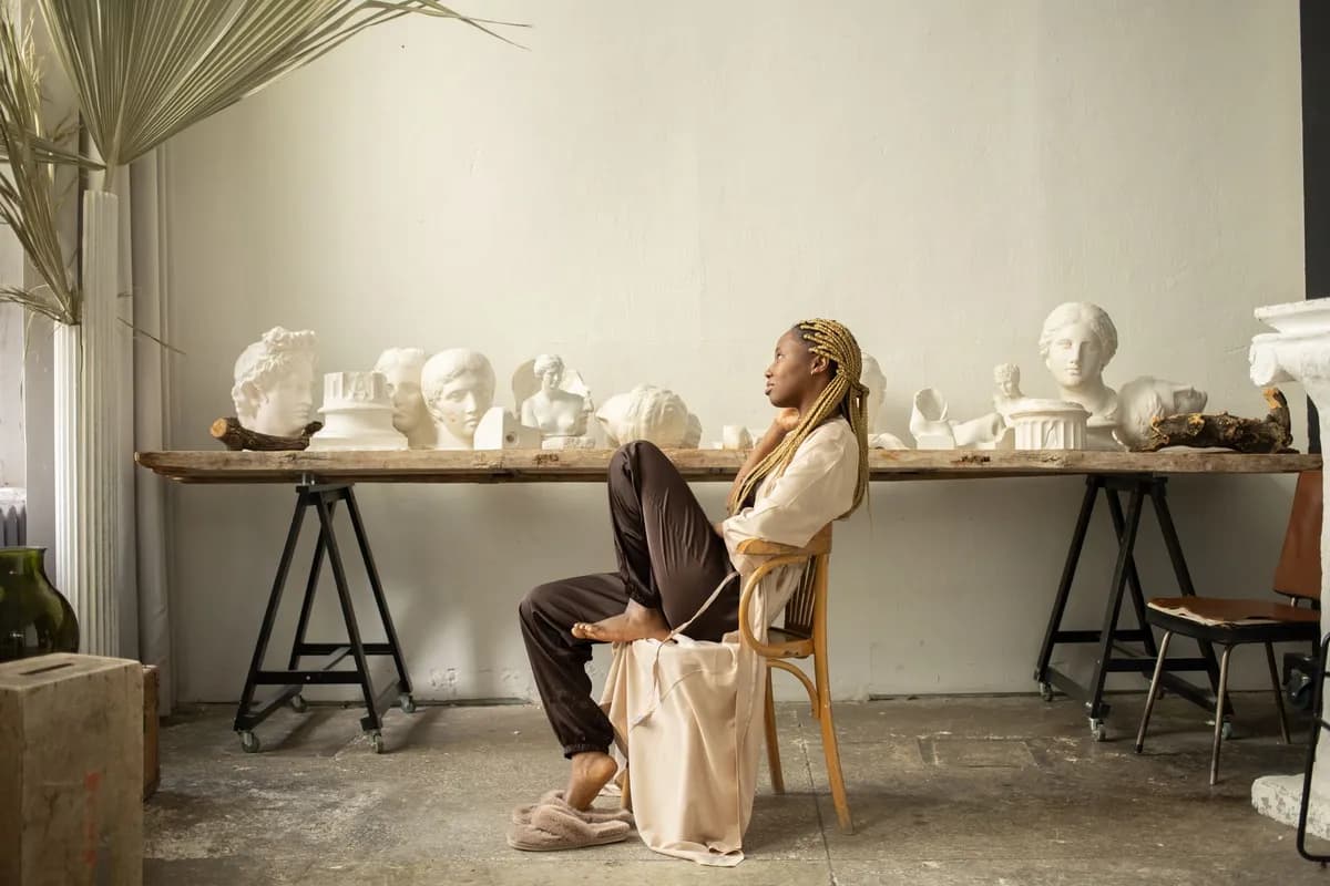 Styliste afro parisienne travaillant des tissus upcyclés dans son atelier lumineux, entre héritage et textile durable