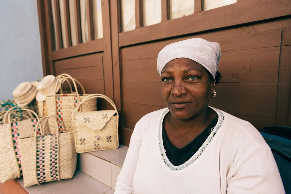 Torréfacteur afro-descendant souriant dans son atelier parisien, sacs de café en arrière-plan
