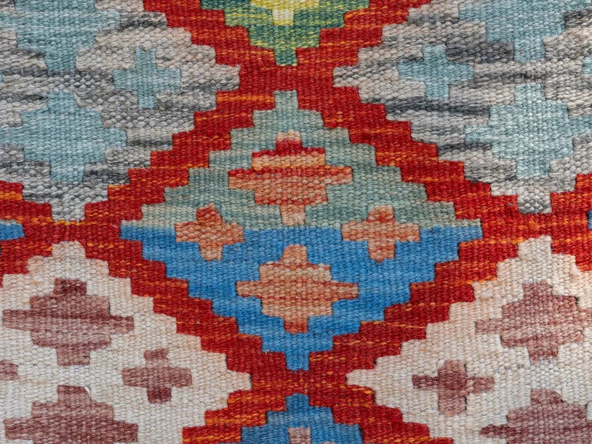Tapis kilim africain aux motifs géométriques tissé main posé dans un salon moderne avec canapé design et plantes vertes
