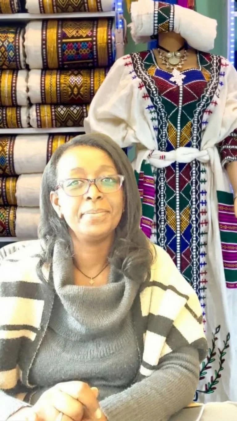 Tadou LETA WAKTOLA, créatrice de LEO&CO, devant ses tissus et tenues éthiopiennes tissés à la main